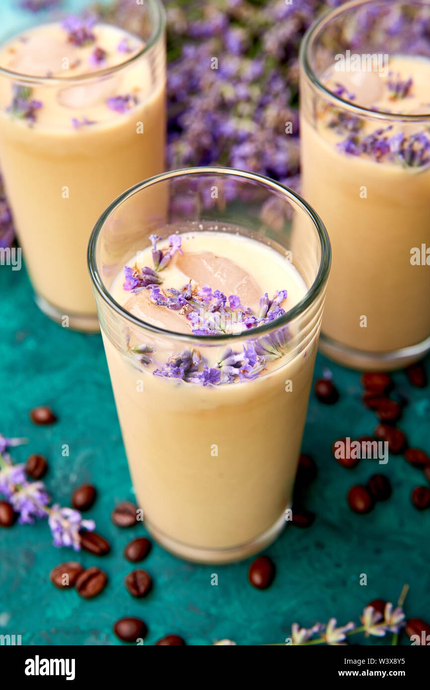 Boisson d'été café glacé à la lavande dans le verre et les grains de café sur fond vert. Bon matin concept. Baeutiful café glace. Banque D'Images