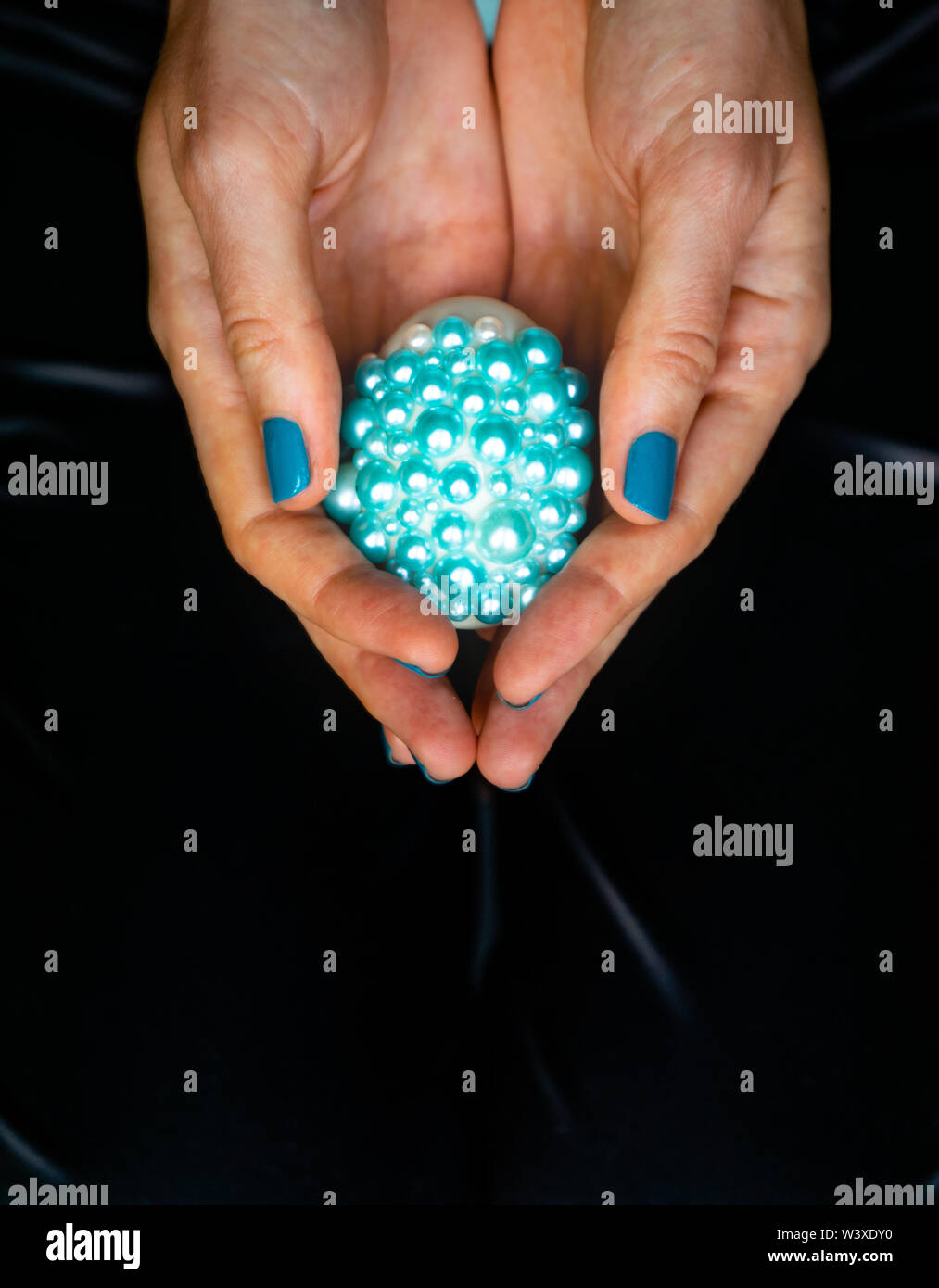 Tatouages féminins mains tiennent oeuf de Pâques décorés. Le concept de couleur turquoise Banque D'Images