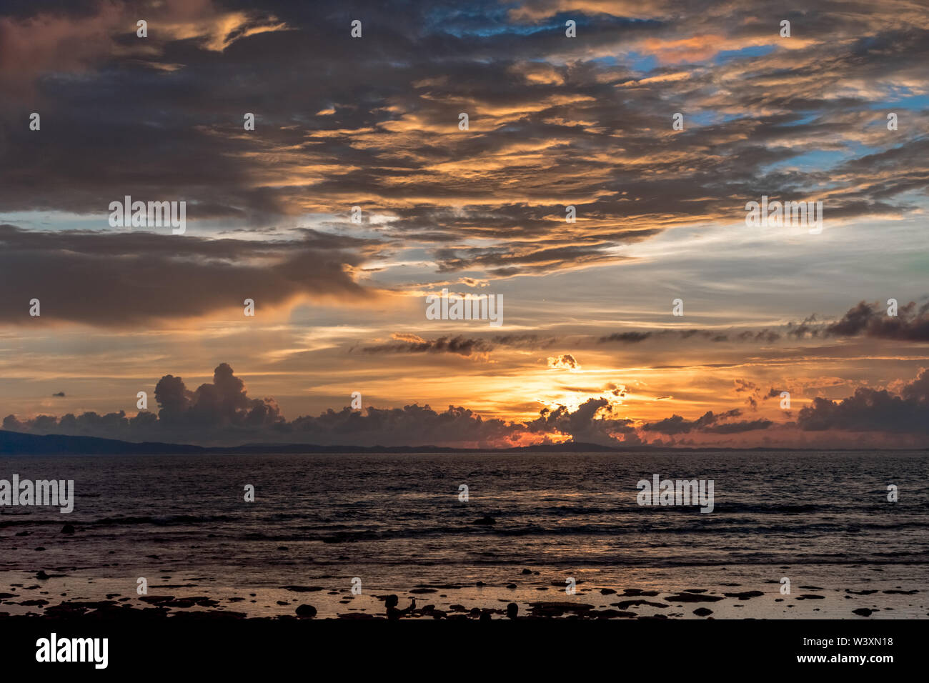 Incroyable coucher/lever du soleil sur les nuages spectaculaires avec dans le ciel, au littoral de l'île tropical exotique Dispersion de la lumière selon la couleur d'onde Banque D'Images