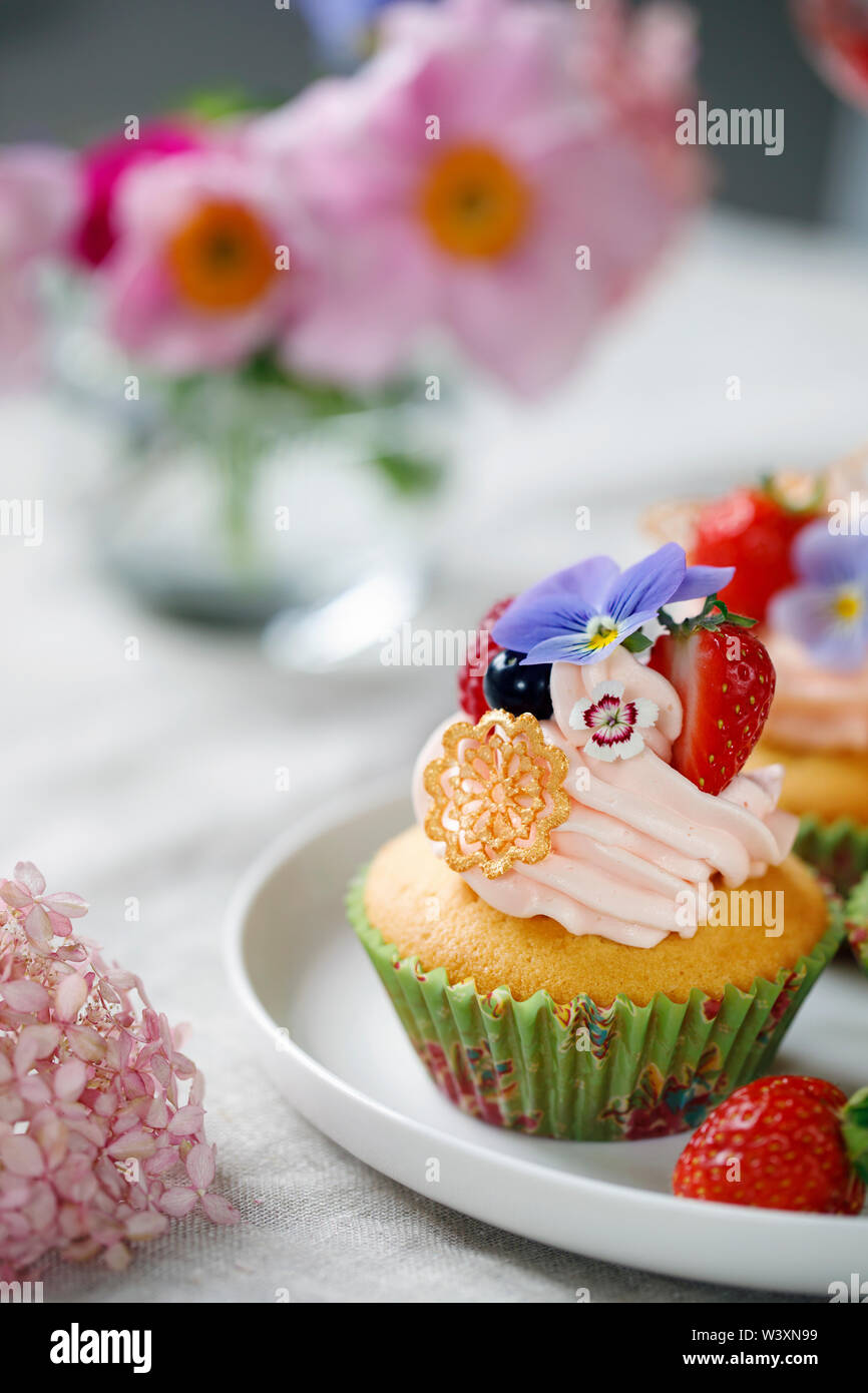 Décorées avec Cupcake buttercream, fruits et fleurs Banque D'Images