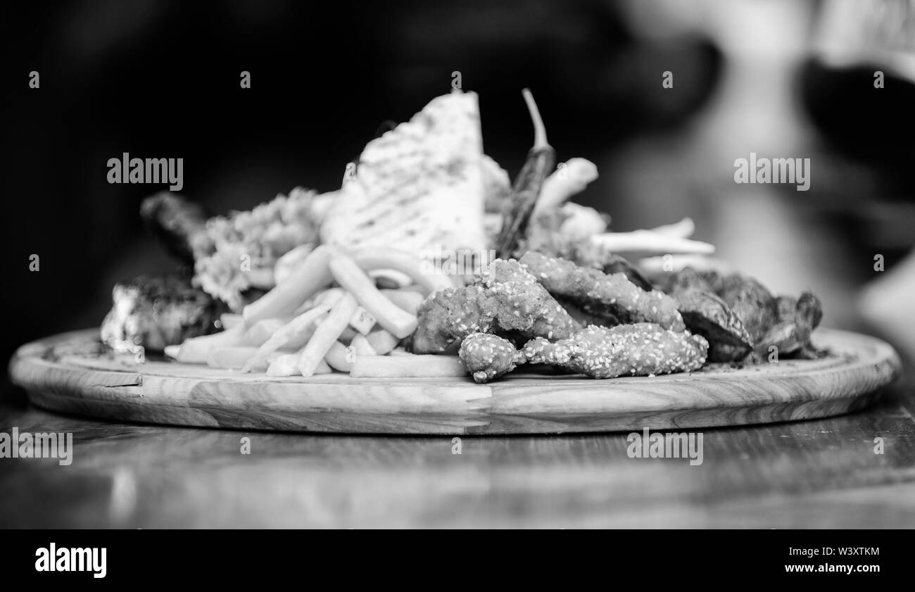 Les repas au restaurant. Snack pour la bière. Planche de bois avec beaucoup de frites et bâtonnets de poisson viande burrito steak servi avec une salade. Menu snack-bar. Calories élevé pour le groupe d'amis. De délicieux en-cas savoureux. Banque D'Images