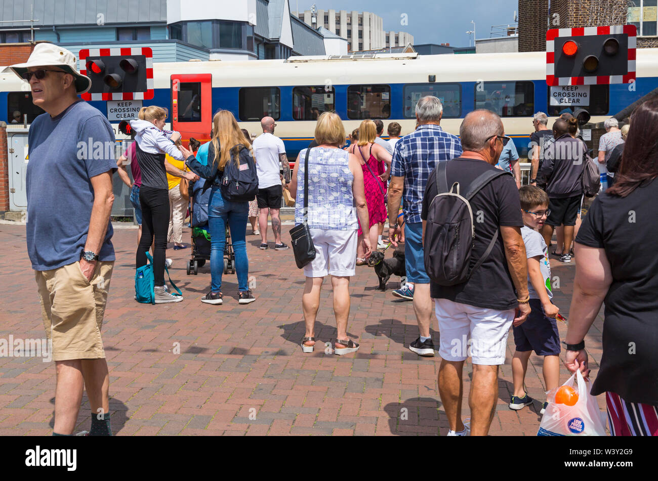 Les piétons en attente à passage à niveau en Poole High Street en train va passé à Poole, Dorset, UK en Juillet Banque D'Images