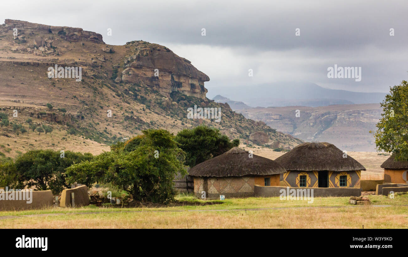 Village culturel Basotho chaume traditionnel ou circulaire ronde rondawel abris contre une montagne dans le parc national rural de l'État libre en Afrique du Sud Banque D'Images