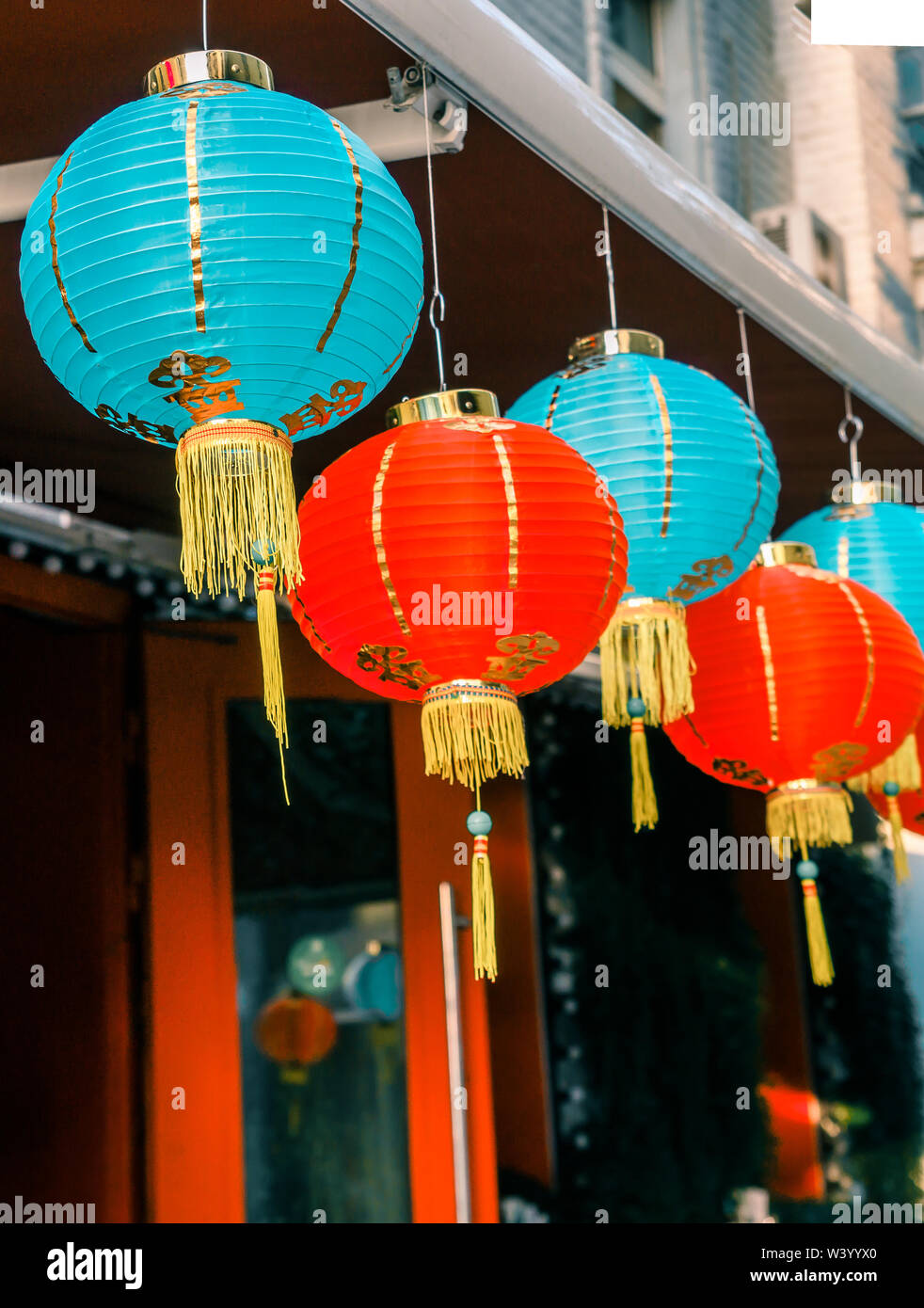 Lanternes de papier chinois sur l'oscillation de vent sur le toit d'un bâtiment par jour dans la rue Banque D'Images