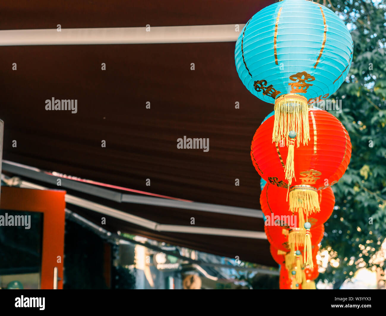 Lanternes de papier chinois sur l'oscillation de vent sur le toit d'un bâtiment par jour dans la rue Banque D'Images