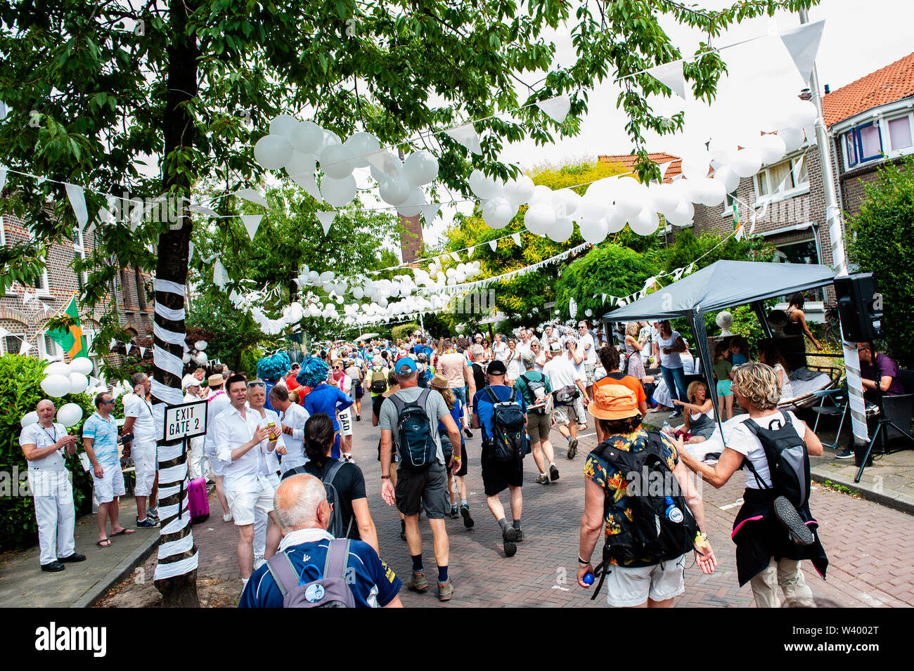 Les participants à un voisinage décorée de blanc pendant le troisième jour.puisque c'est la plus grande épreuve de marche de plusieurs jours, les quatre jours le mois de mars est considéré comme le premier exemple d'esprit sportif et les liens entre militaires et civils et les femmes de nombreux pays différents. Le troisième jour à vélo est bien connue en raison de ses sept collines, qui sont toujours un défi pour les marcheurs. Certains des quartiers de Nijmegen célébrer l'arrivée des promeneurs en décorant les façades de maisons et beaucoup de parties, ce qui est toujours un très bon accueil de la part Banque D'Images