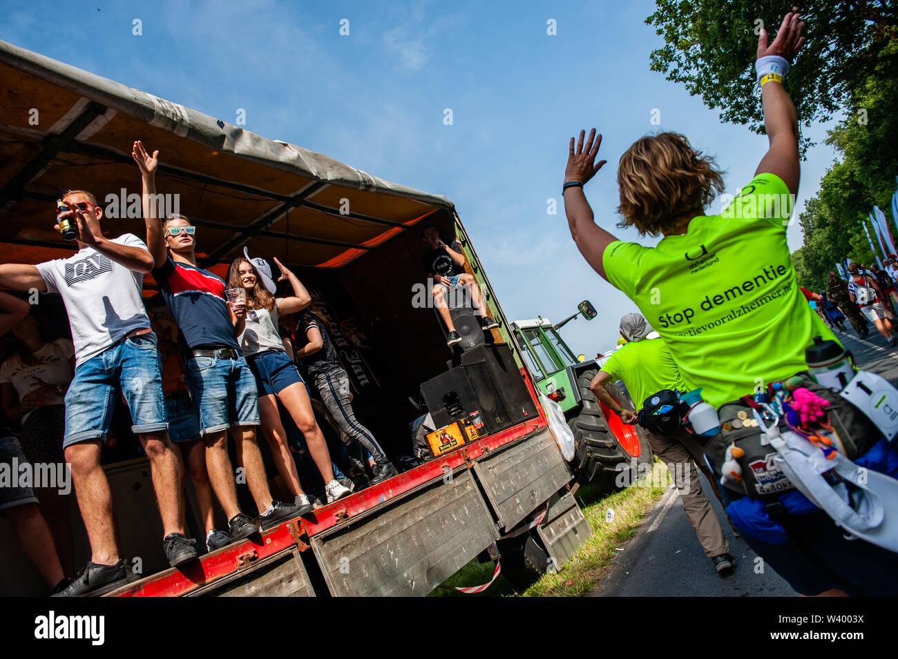 Les jeunes participants applaudissent d'un camion au cours de la troisième journée.puisque c'est la plus grande épreuve de marche de plusieurs jours, les quatre jours le mois de mars est considéré comme le premier exemple d'esprit sportif et les liens entre militaires et civils et les femmes de nombreux pays différents. Le troisième jour à vélo est bien connue en raison de ses sept collines, qui sont toujours un défi pour les marcheurs. Certains des quartiers de Nijmegen célébrer l'arrivée des promeneurs en décorant les façades de maisons et beaucoup de parties, ce qui est toujours un très bon accueil aux participants. Banque D'Images