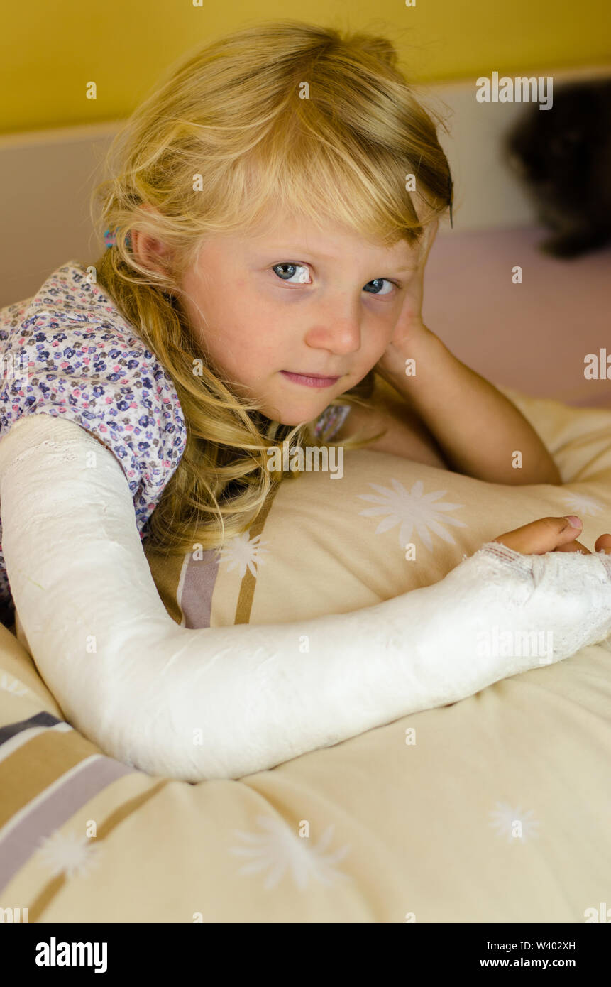 Blessé fille blonde avec fracture de la main à bandage Banque D'Images