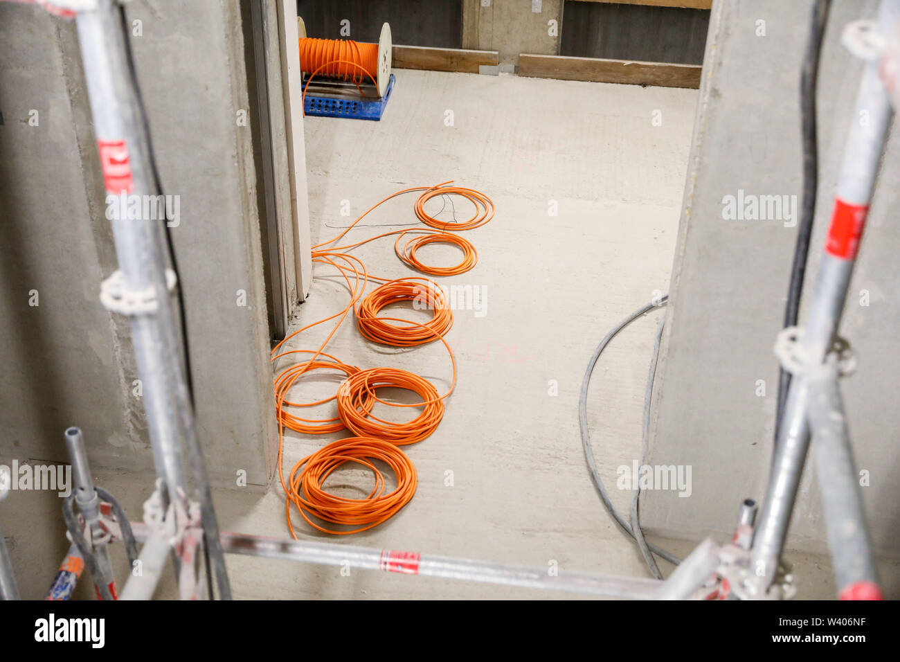 26 juin 2019, Saxe, Leipzig : Câbles pour l'installation électrique sont situés dans le shell de la soi-disant 'Lipsia Tower' dans le district de Leipzig-Grünau. Le même jour, l'écimage-out cérémonie a eu lieu pour la première réunification des tours dans le nouveau quartier de Leipzig Grünau des années 70 et 80. Dans l'avenir il y aura de 60 appartements sur 13 étages dans la chambre. La coopérative d'habitation Lipsia investit un bon 13 millions d'euros. Après des décennies d'abandon et la démolition de bâtiments préfabriqués vide, le nombre d'habitants est à la hausse pour la première fois. Photo : Jan Woi Banque D'Images