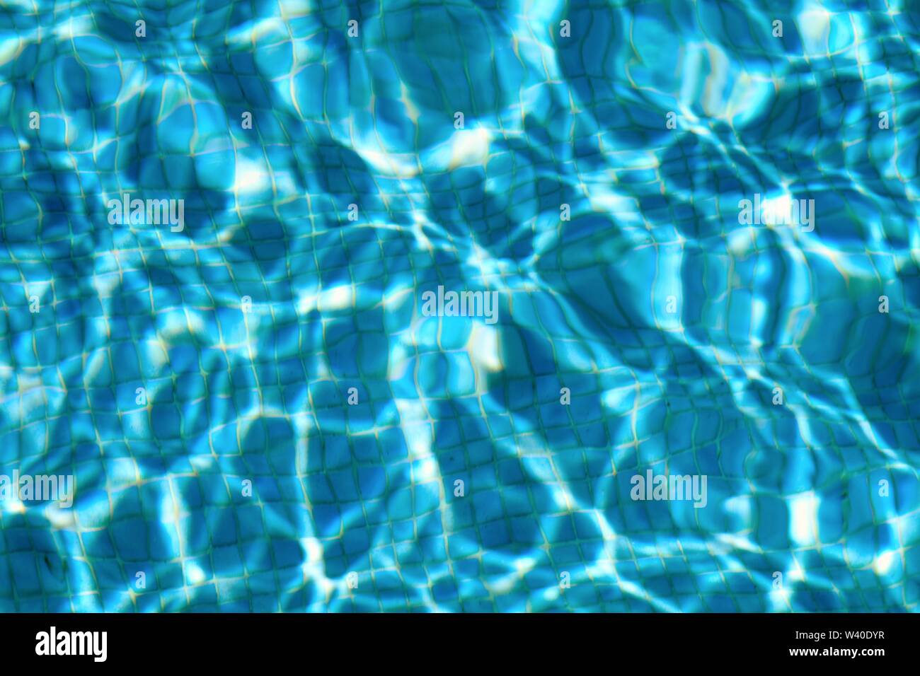 Motifs abstraits formés par la forte lumière du soleil sur la surface de l'eau dans une piscine semblable à David Hockney's tableaux célèbres Banque D'Images