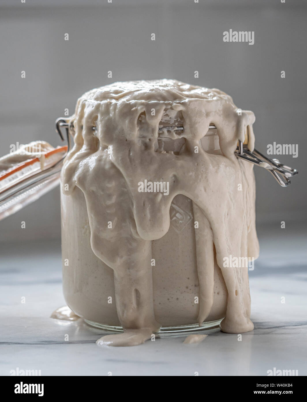 Levain culture débordant kilner jar dans cuisine en raison de la fermentation explosive Banque D'Images