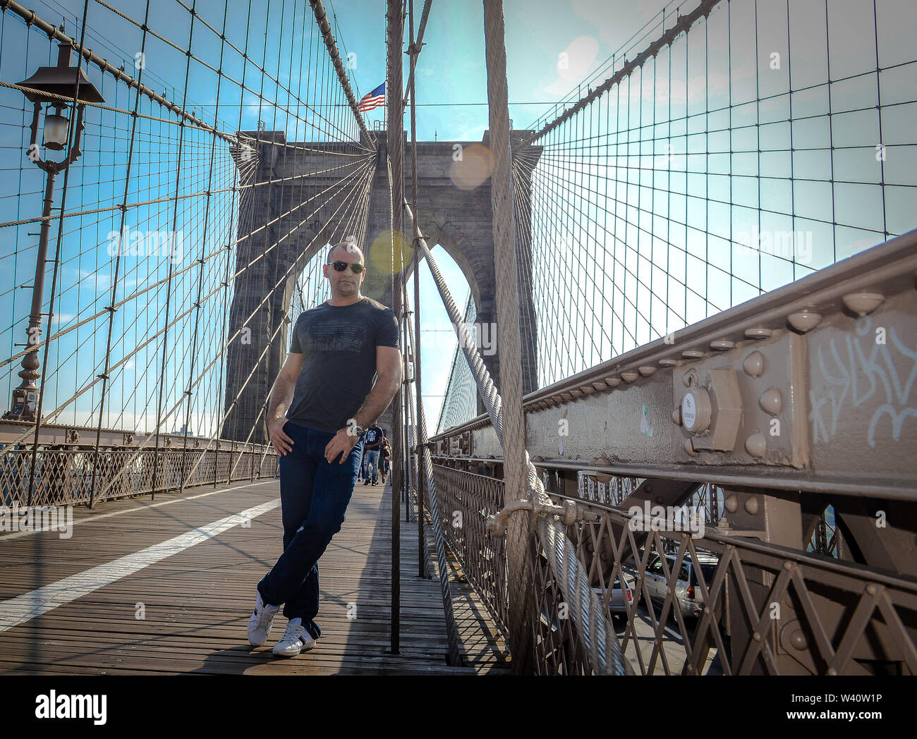 Jeune homme posant sur le pont de Brooklyn sur sunny day Photo Stock - Alamy