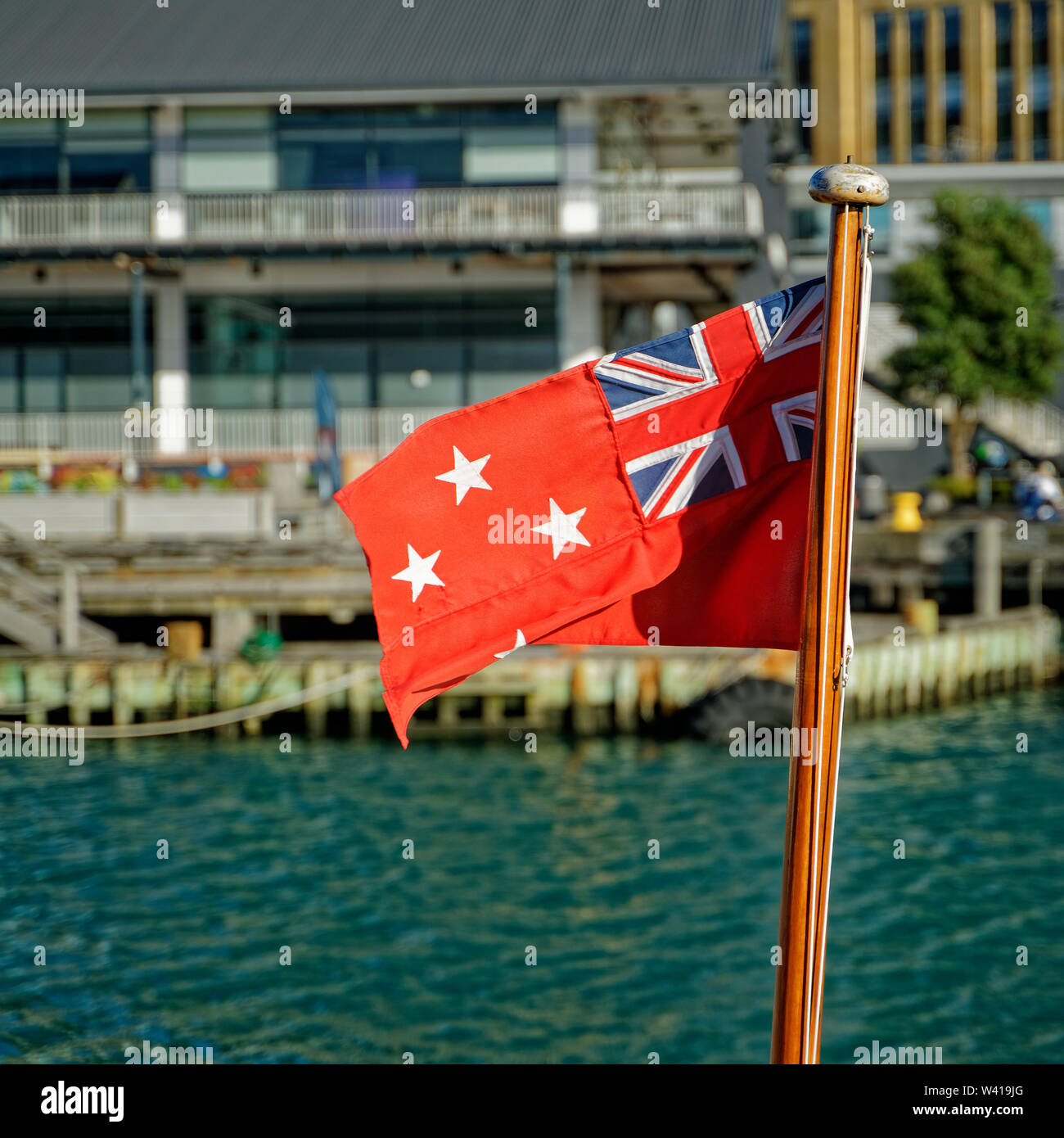 Wellington, Wellington/Nouvelle-Zélande - 25 mai 2019 : Nouvelle Zélande Red Ensign palpitations dans une brise dans le port de Wellington, Nouvelle-Zélande. Banque D'Images