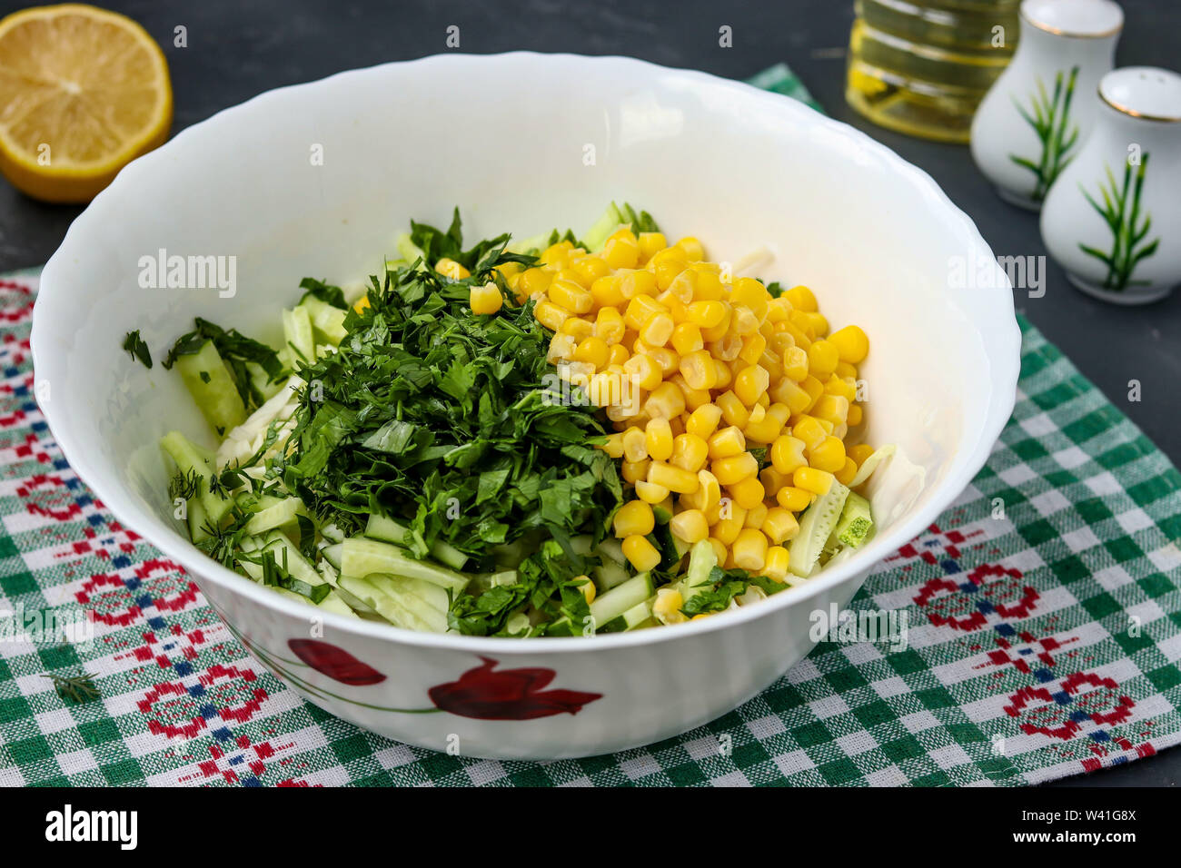 La cuisson salade saine avec du chou, concombres et maïs, photo horizontale, trancher le persil dans une salade, close-up Banque D'Images