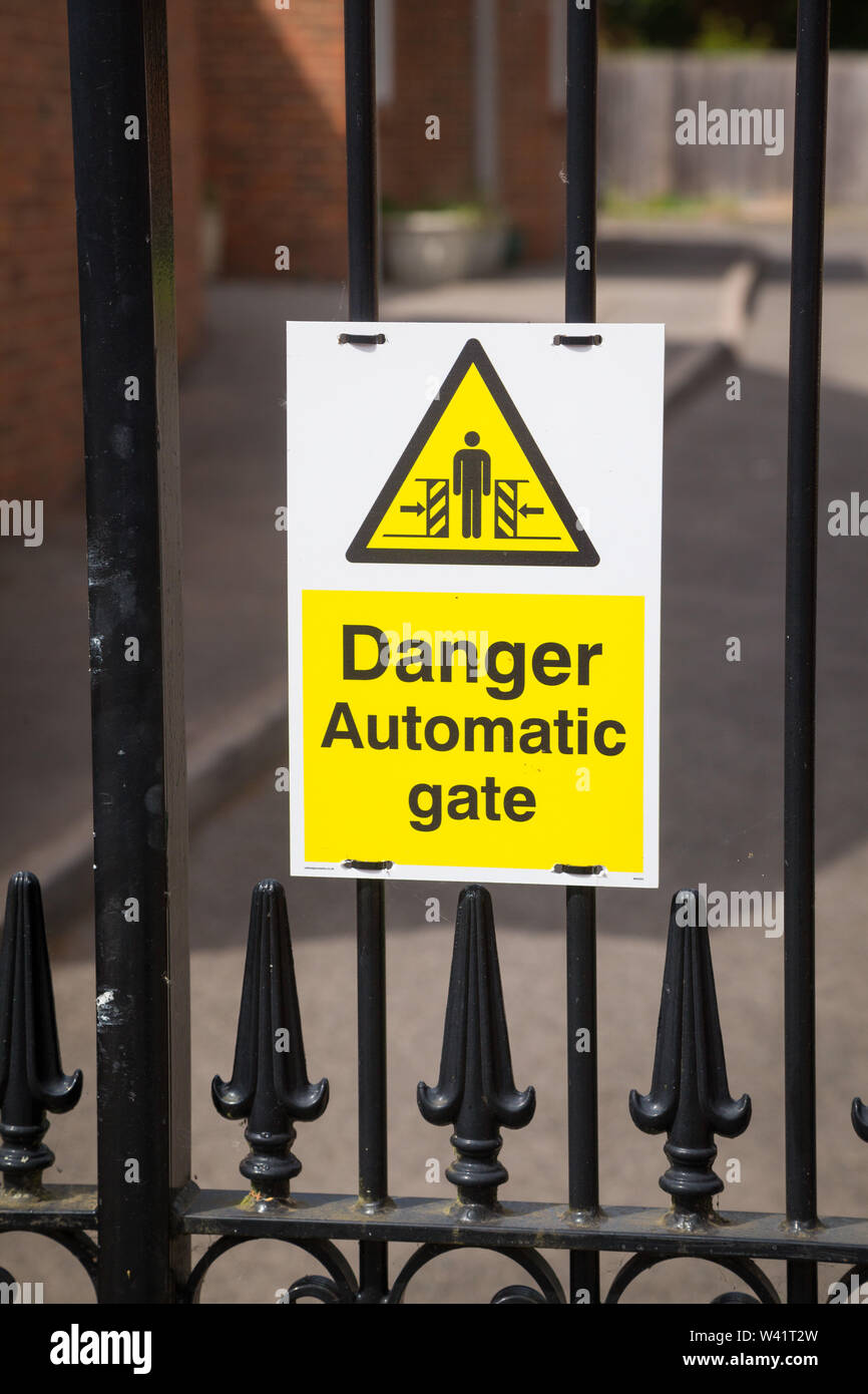 Un "danger Portail automatique' signe sur un portail électrique. Banque D'Images