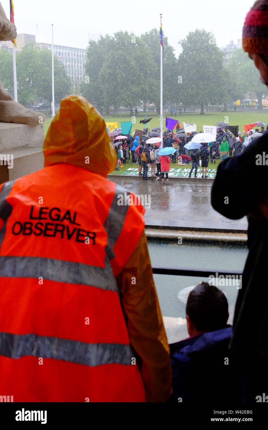 Bristol, Royaume-Uni. 19 juillet 2019. La pluie se déverse sur la rébellion d'extinction d'un rassemblement sur la jeunesse College Green dans le centre-ville de Bristol. C'est le 5e jour de la protestation contre le changement climatique dans la ville. Un observateur juridique montres de l'abri de la chambre du conseil. Crédit : Mr Standfast/Alamy Live News Banque D'Images