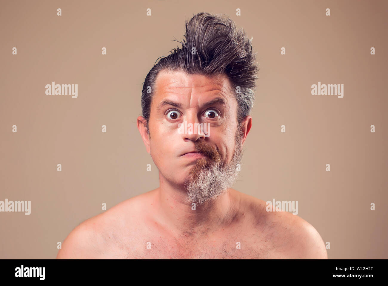 Portrait d'un homme avec la moitié de la barbe et cheveux sur fond brun Banque D'Images