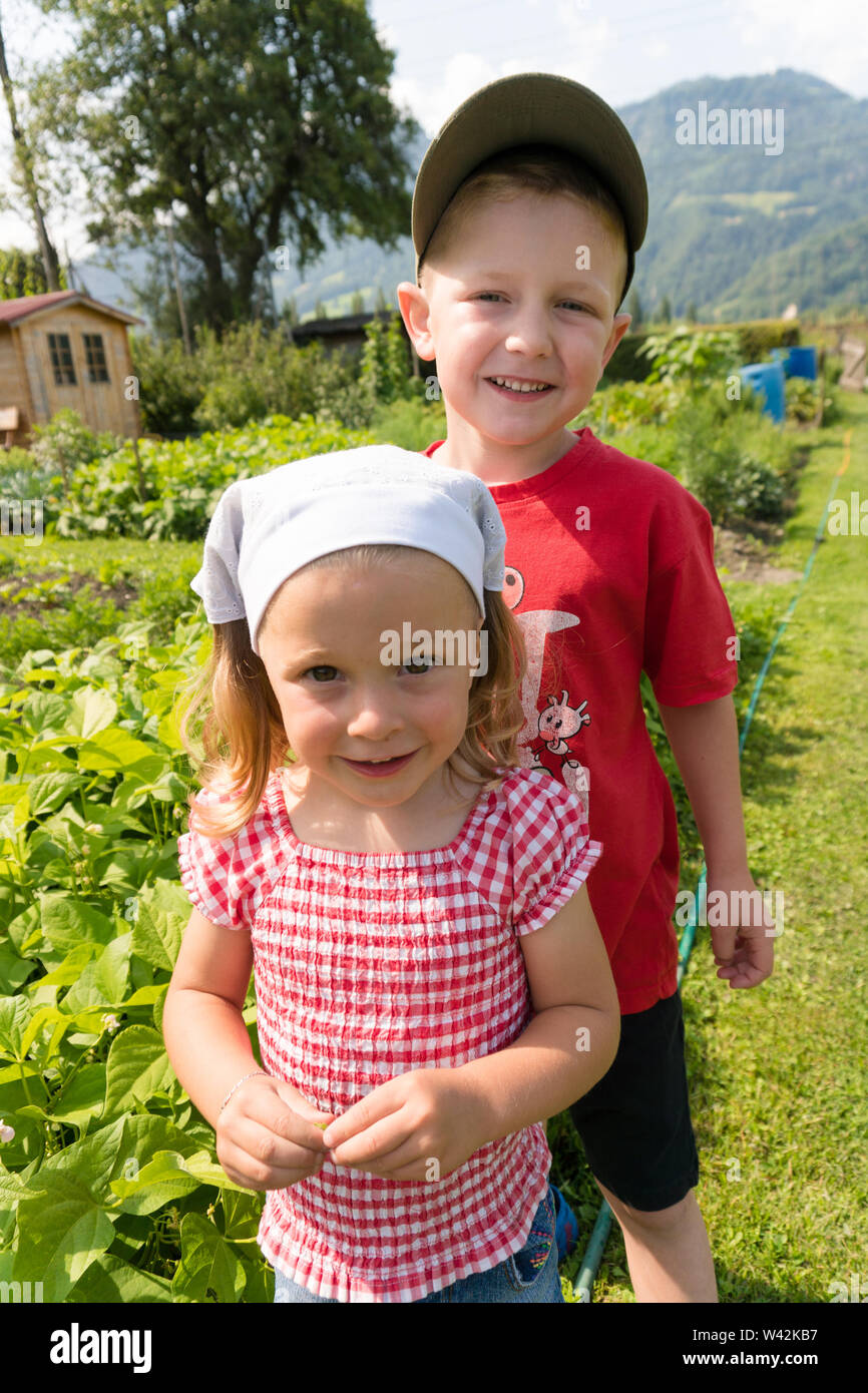 Jeune fille et plus borther stad fièrement en en face de leur potager dans la campagne suisse Banque D'Images