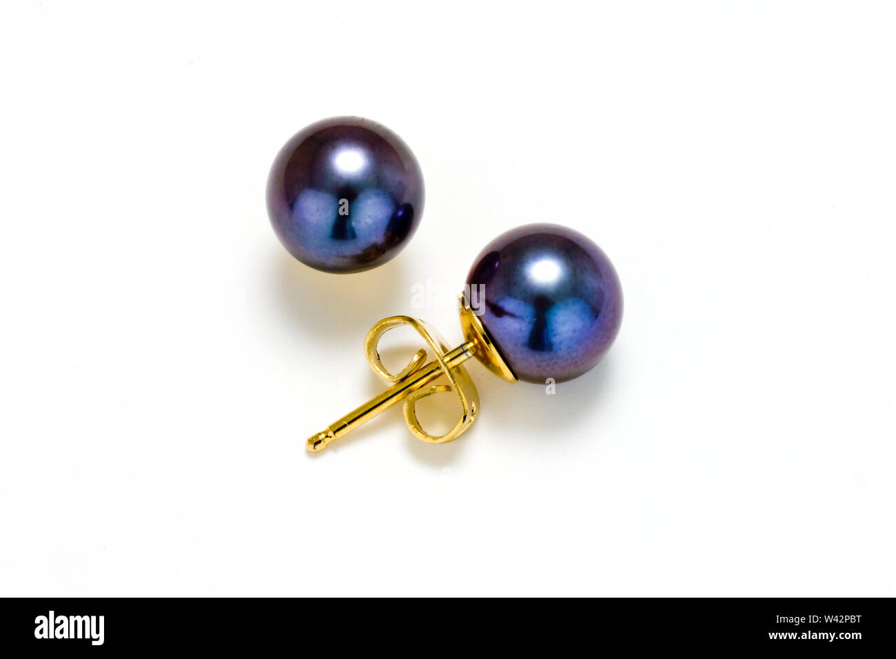 Black Pearl earring les goujons avec postes d'or sur un fond blanc. Banque D'Images