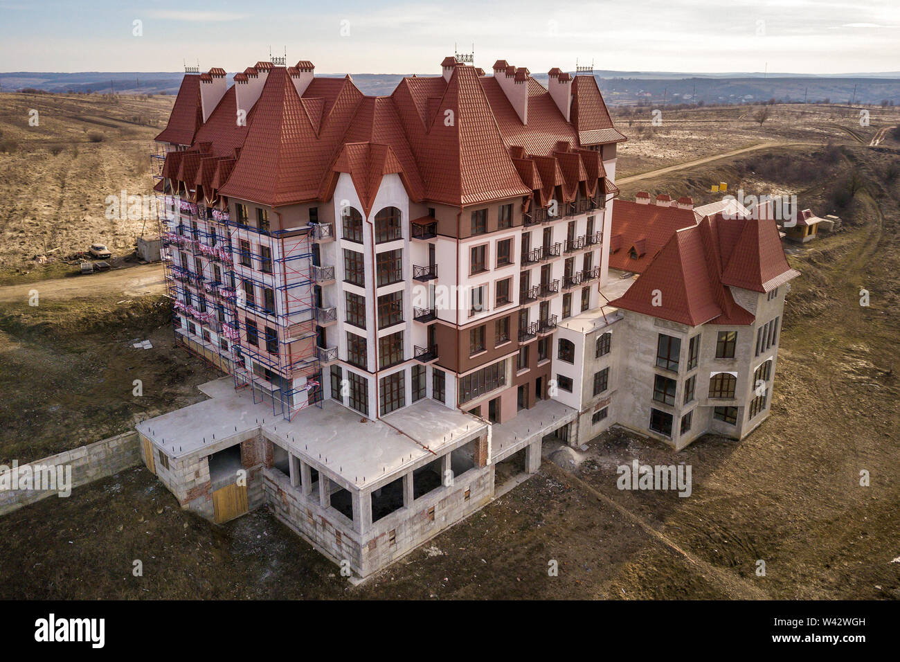 Vue aérienne de la résidence, hôtel multistoried inachevé ou un chalet immeuble avec mur en stuc, balustrades en fer, toit de bardeaux raide et brillant Banque D'Images