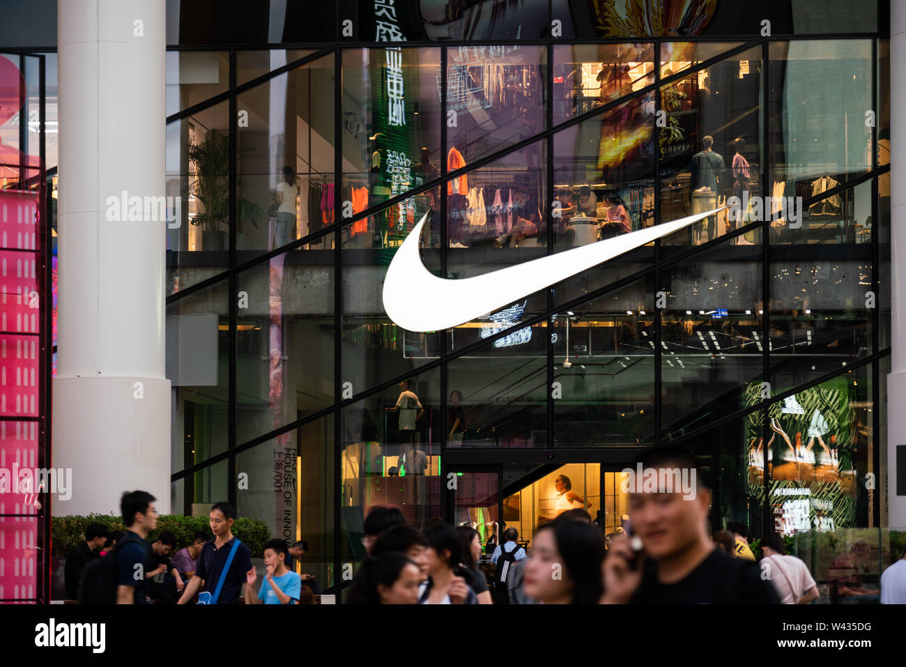 Une multinationale américaine société logo Nike Sportswear vu à Shanghai avec les piétons en passant devant elle. Banque D'Images