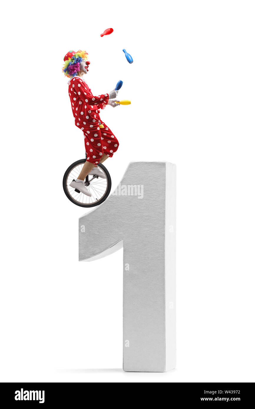 De toute la longueur d'un clown jonglage et équitation un monocycle sur un numéro un géant isolé sur fond blanc Banque D'Images