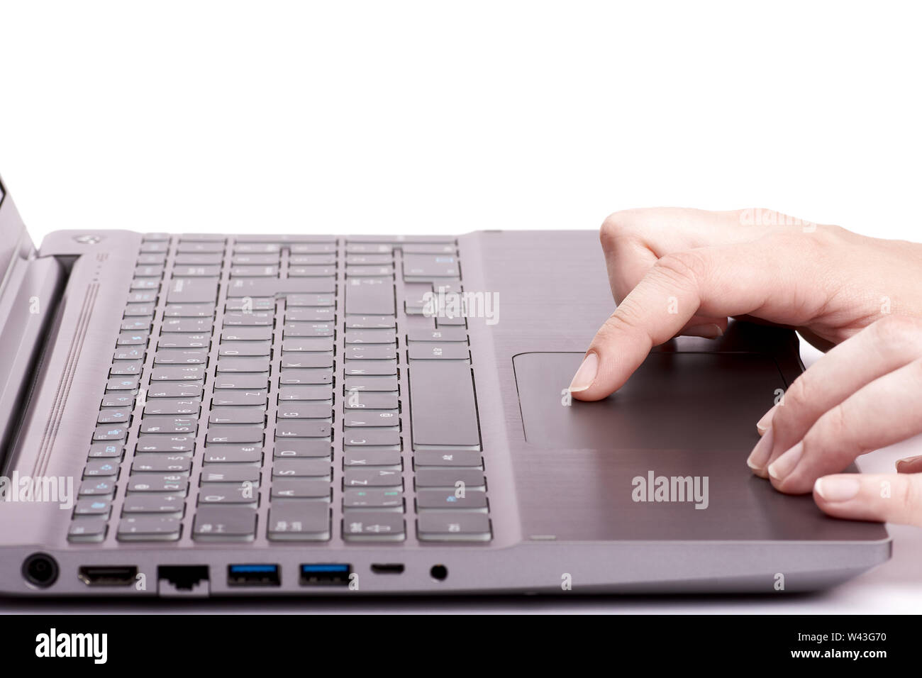 Jeune femme part travailler sur un ordinateur portable d'argent avec touchpad clavier noir. Isolé sur fond blanc. Banque D'Images