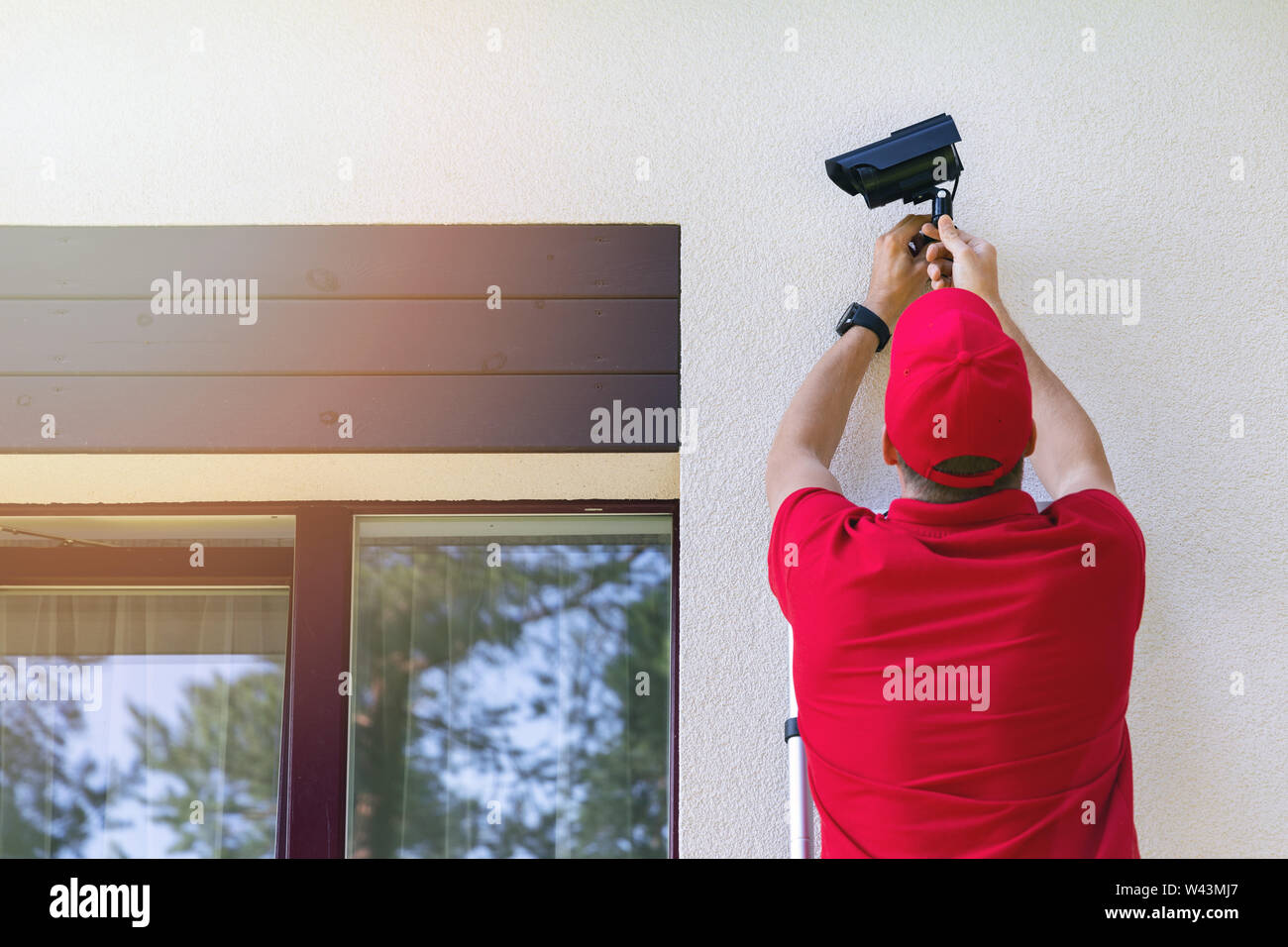 La sécurité extérieure installation technicien surveillance camera sur mur extérieur de maison Banque D'Images