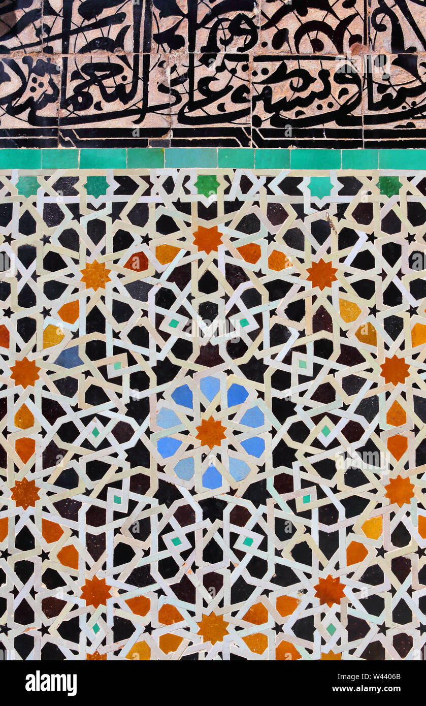 Fes, Maroc. Détail d'un vieux mur patio décoré de carreaux de céramique émaillés en mosaïque de style islamique et de calligraphie arabe. Banque D'Images