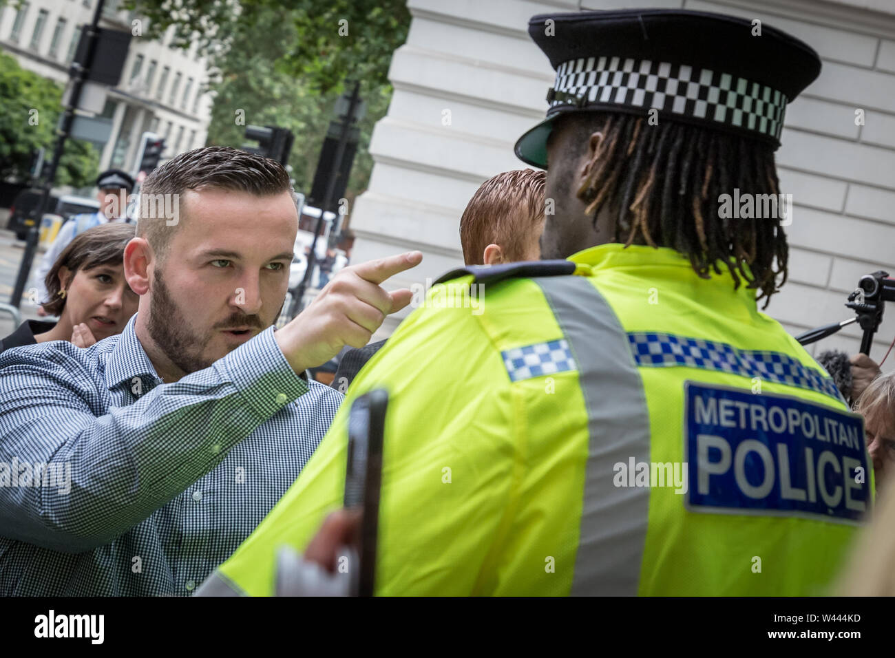 Londres, Royaume-Uni. 19 juillet 2019. James Goddard, 30 ans, de Timperley à Altrincham, confronte un policier en dehors de Westminster Magistrates' Court. Le soi-disant chef de la UK's 'yellow vest' pro-Brexit mouvement nationaliste fait face à un procès de deux jours d'accusations de harcèlement sexuel après le député conservateur Anna Soubry a été appelé un "nazi", "traître" et "racaille" en marchant à la Chambre des communes entre le 18 décembre de l'année dernière et 8 janvier. Goddard a également admis à l'abus d'un agent de police raciste à l'extérieur du parlement. Mme Soubry elle-même devrait donner la preuve. Crédit : Guy Josse/Alamy vivre Banque D'Images