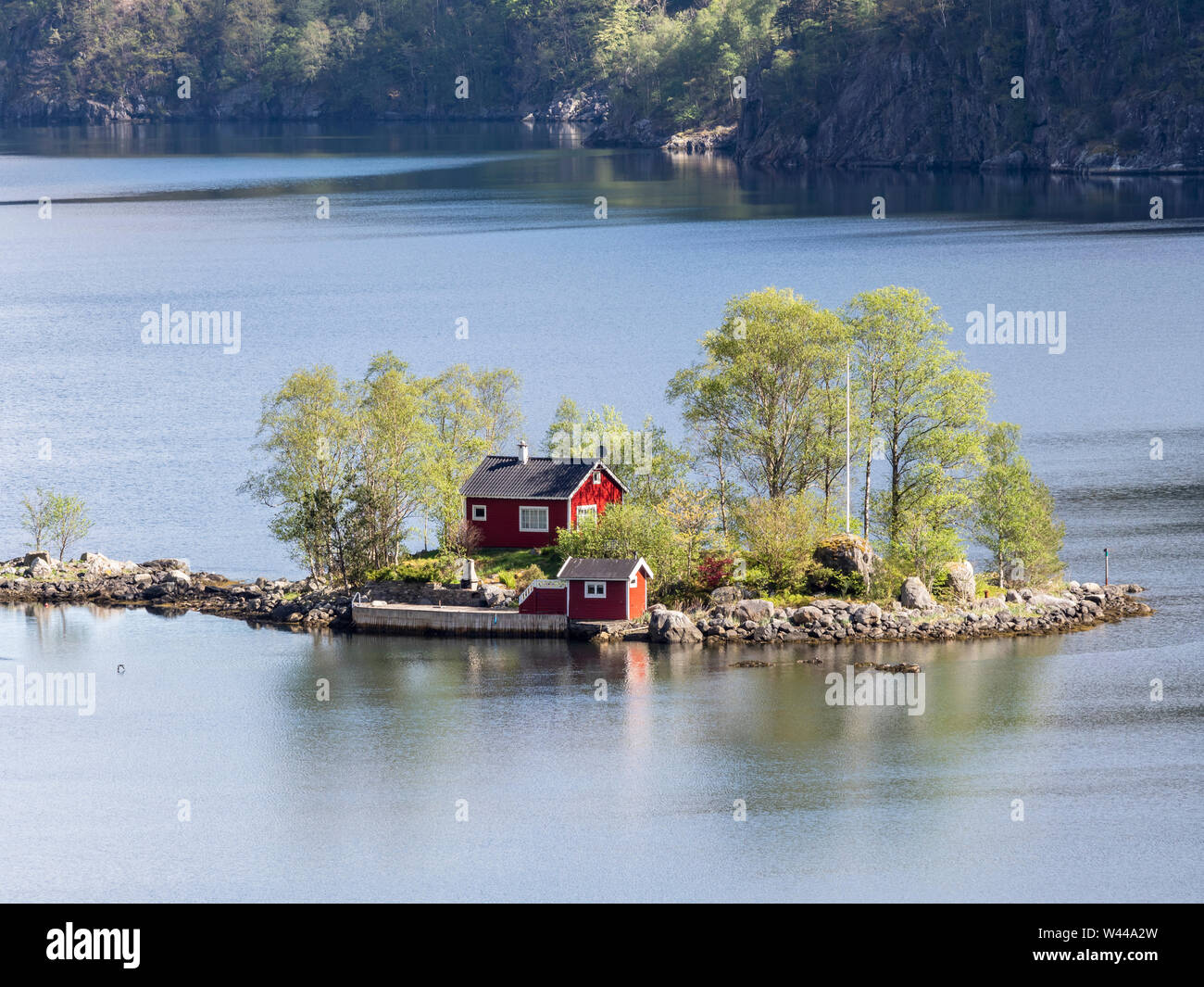 Rouge typique chalet norvégien sur une petite île dans le fjord, Lovrafjord, Norvège Banque D'Images