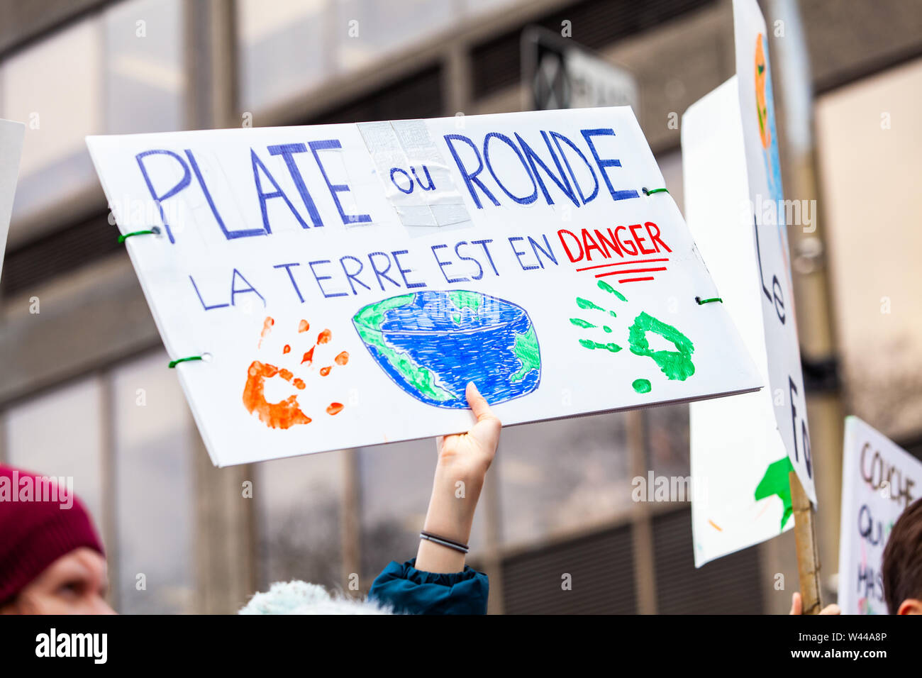 Un protestataire est titulaire d'un signe de l'expression française plat ou rond, la terre est en danger au cours d'une rue bondée de protestation contre le changement climatique. Banque D'Images