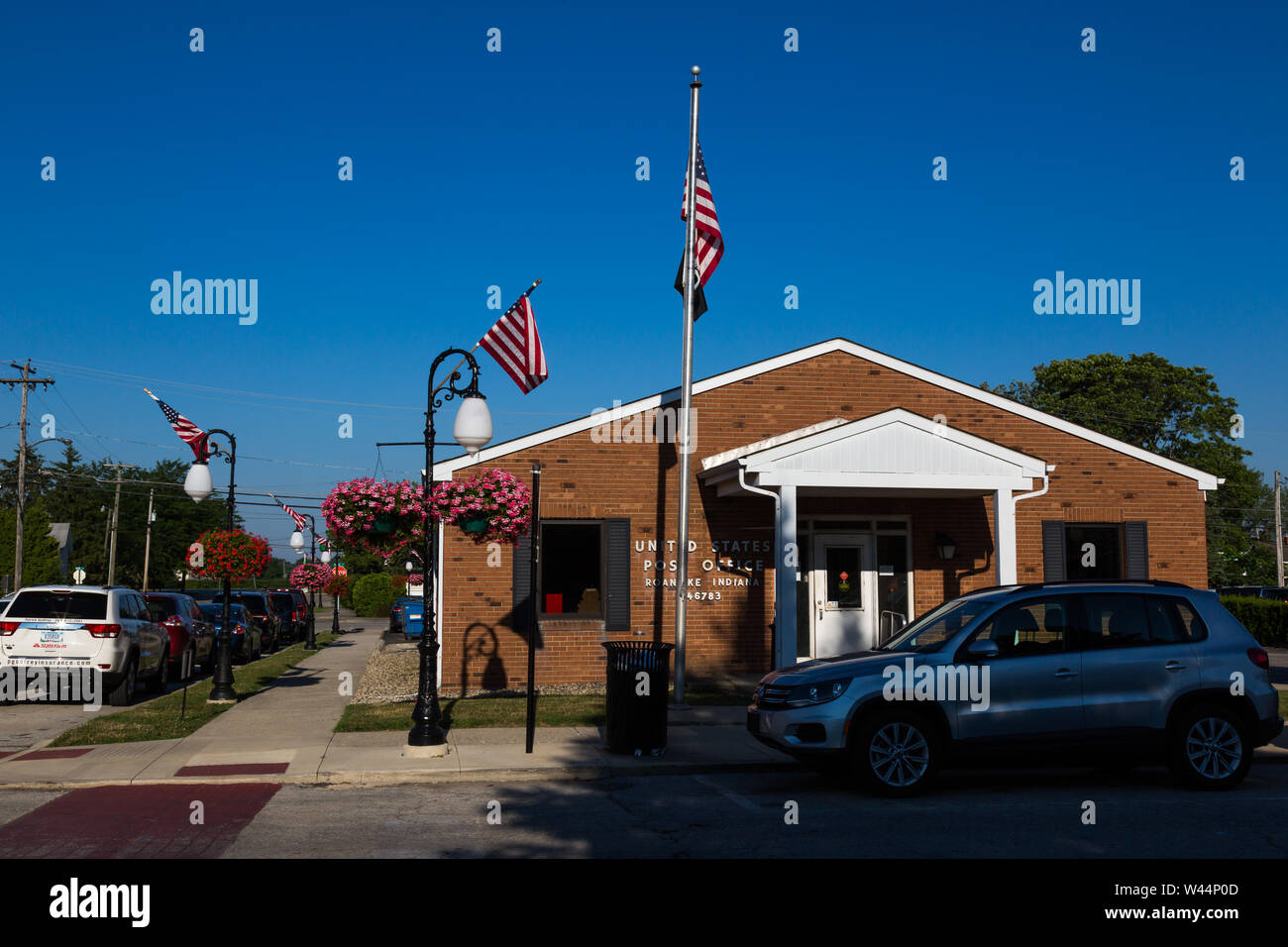 Fleurs et drapeaux décorent le United States Post Office building au centre-ville de Roanoke, Indiana, USA. Banque D'Images
