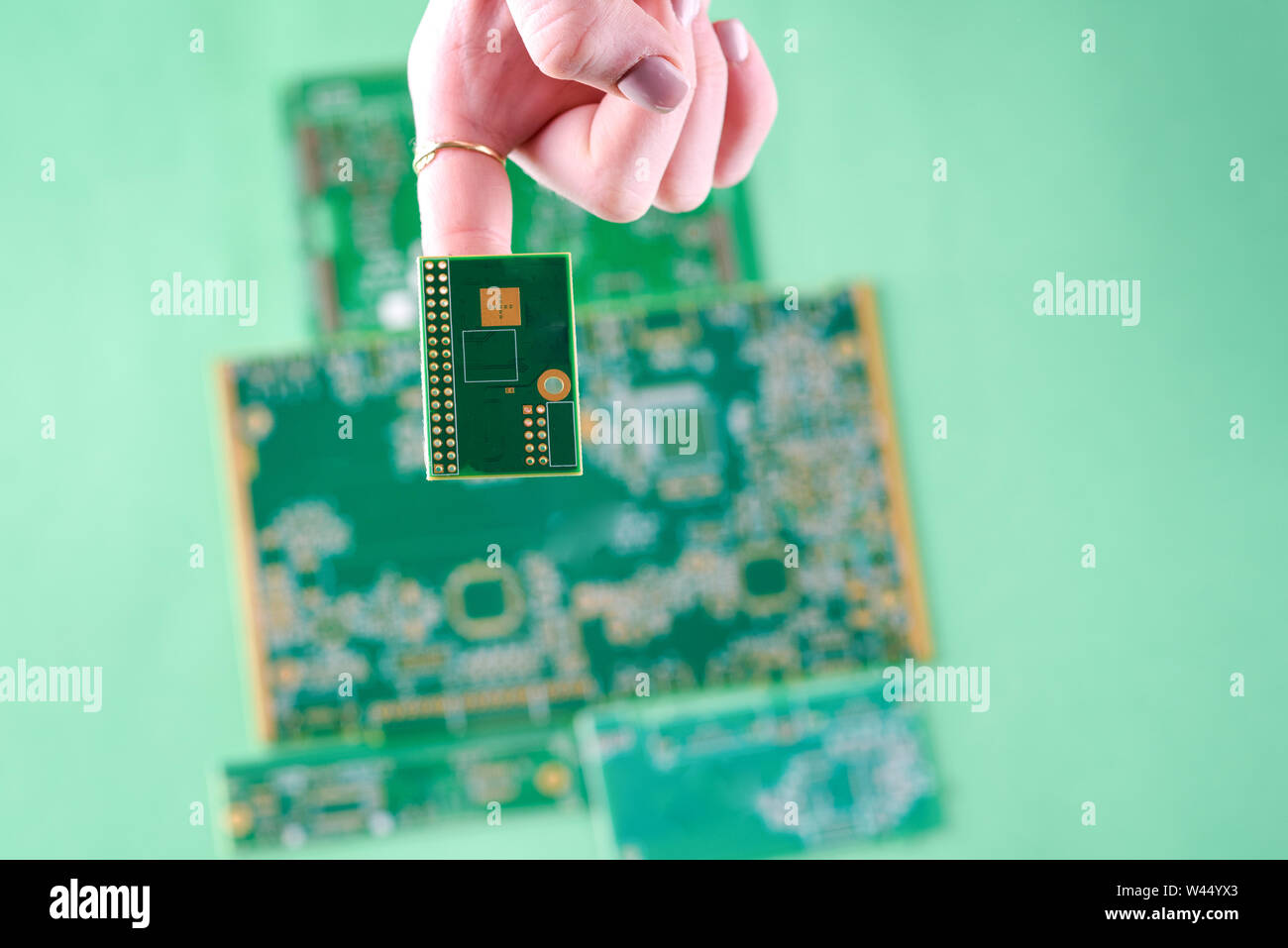 Petits appareils électroniques Circuits imprimés sur les femme doigt. L'inspection de technicienne de défaillance du circuit de sélection. Banque D'Images