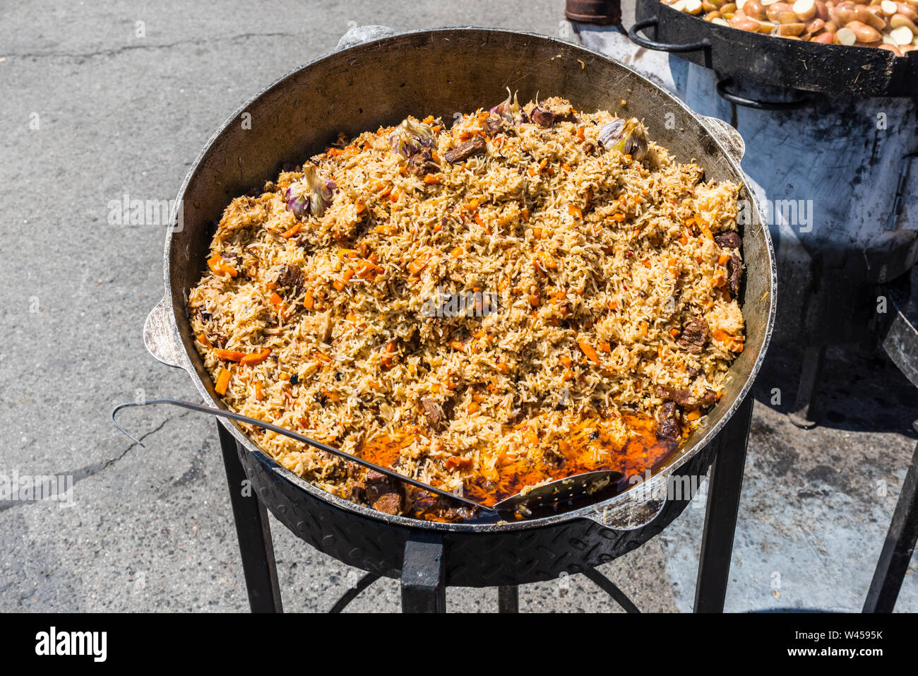 Plat traditionnel de la cuisine orientale - pilaf avec de la viande dans une plus grande la tva sur la rue pendant le festival Banque D'Images