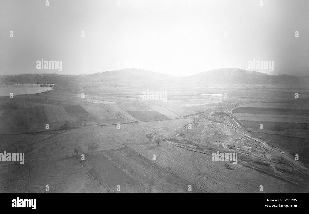 Conreus al costat d'un llac i les muntanyes al fons restauré. Banque D'Images