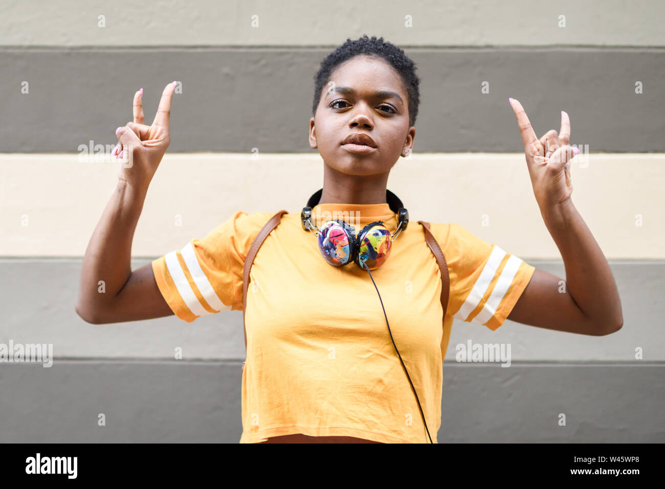 Jeune femme noire faisant le geste de les cornes avec ses mains à l'extérieur. Banque D'Images