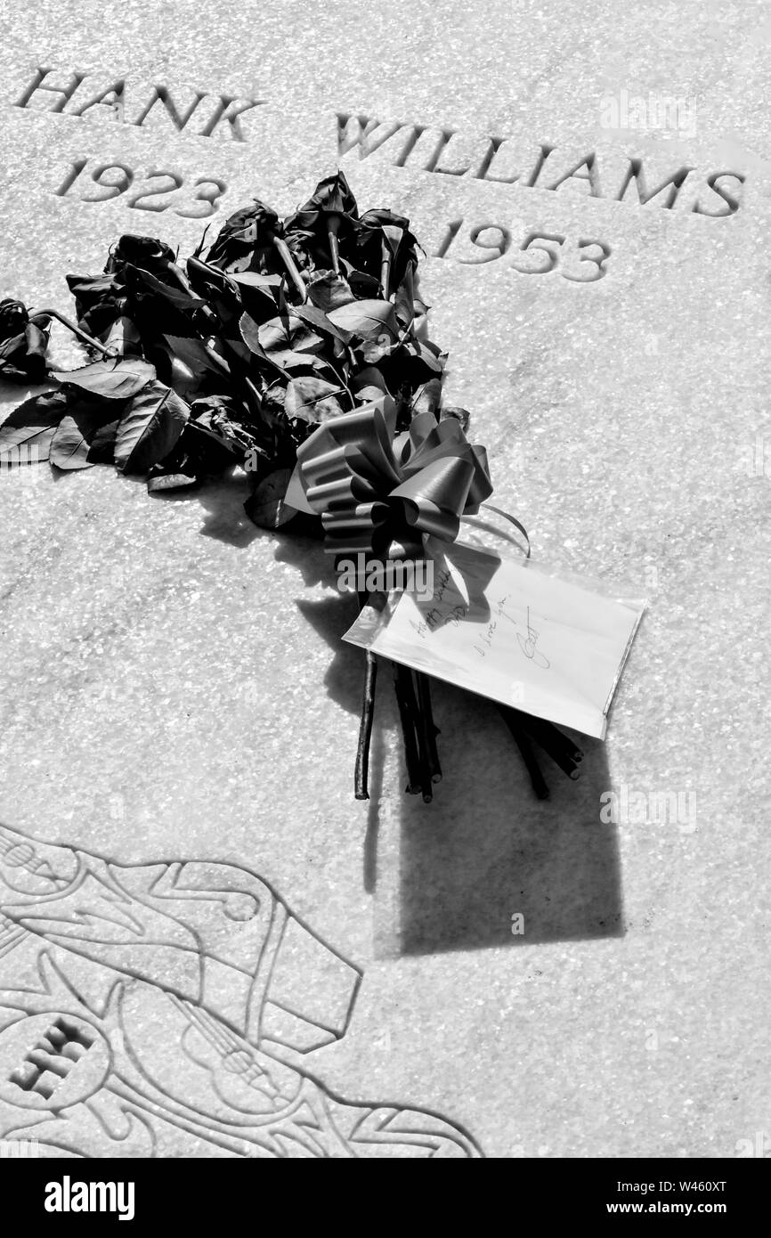 Le flétrissement d'un bouquet de roses rouges avec une carte "Joyeux anniversaire papa, je vous aime, Jett', sur la pierre tombale de Hank Williams, Père, à Montgomery, AL Banque D'Images