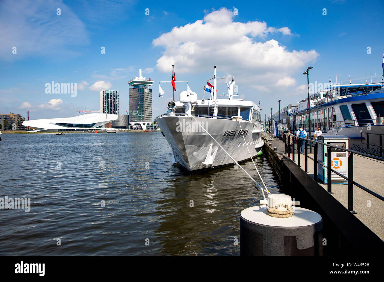 Amsterdam, Pays-Bas, rivière Ij, rivière bateaux de croisière à l'embarcadère, le Musée du Cinéma et de l'Œil l'A'DAM Lookout Tower de l'événement à l'arrière, Banque D'Images
