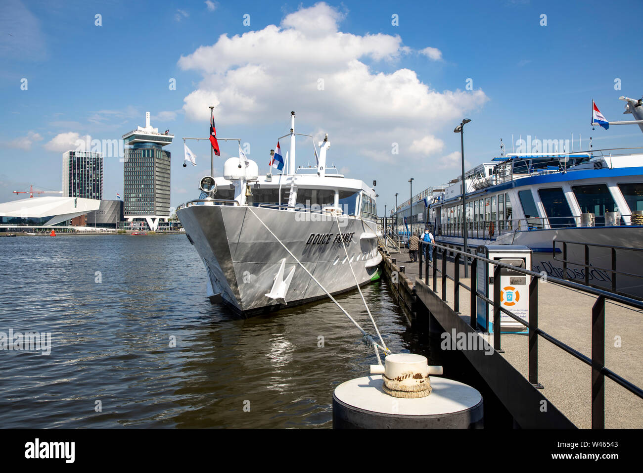 Amsterdam, Pays-Bas, rivière Ij, rivière bateaux de croisière à l'embarcadère, le Musée du Cinéma et de l'Œil l'A'DAM Lookout Tower de l'événement à l'arrière, Banque D'Images