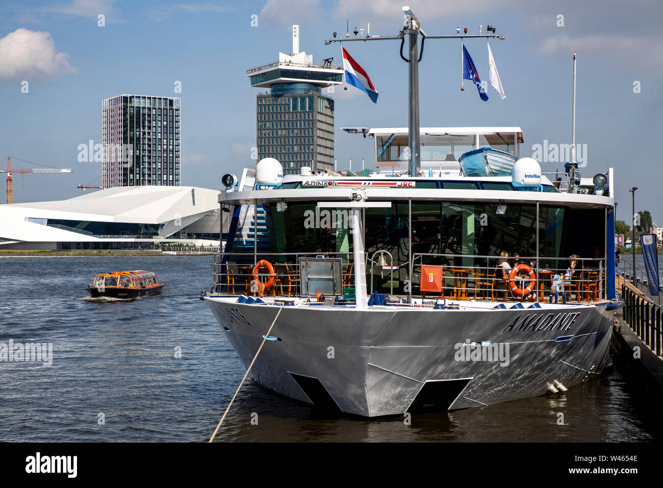 Amsterdam, Pays-Bas, rivière Ij, rivière bateaux de croisière à l'embarcadère, le Musée du Cinéma et de l'Œil l'A'DAM Lookout Tower de l'événement à l'arrière, Banque D'Images