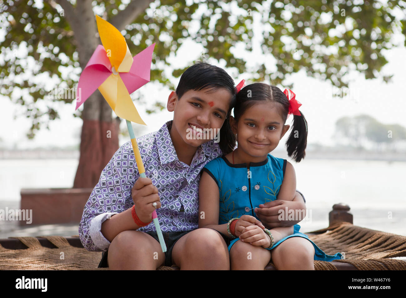 Boy holding pinwheel with his sister Banque D'Images