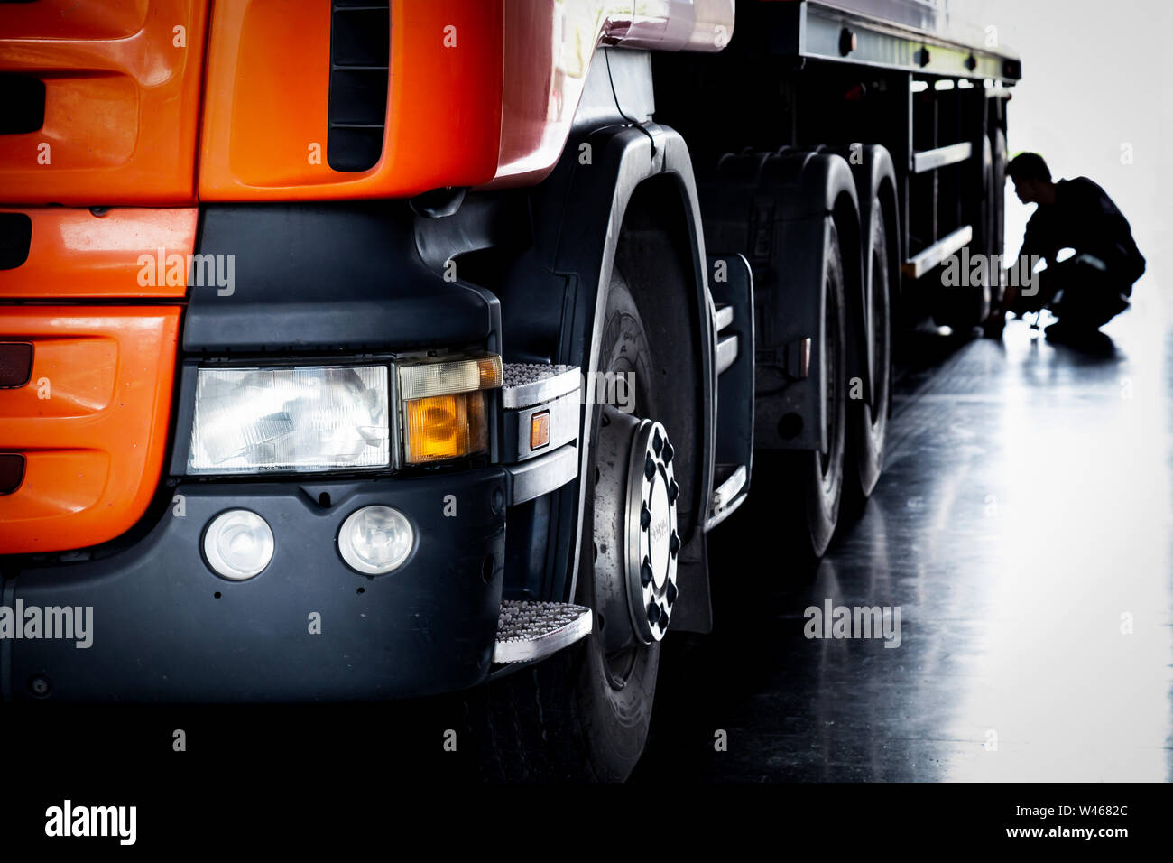 Mécanicien automobile Contrôle des pneus et la réparation des tracteurs routiers semi brisée dans le garage, selective focus. Banque D'Images
