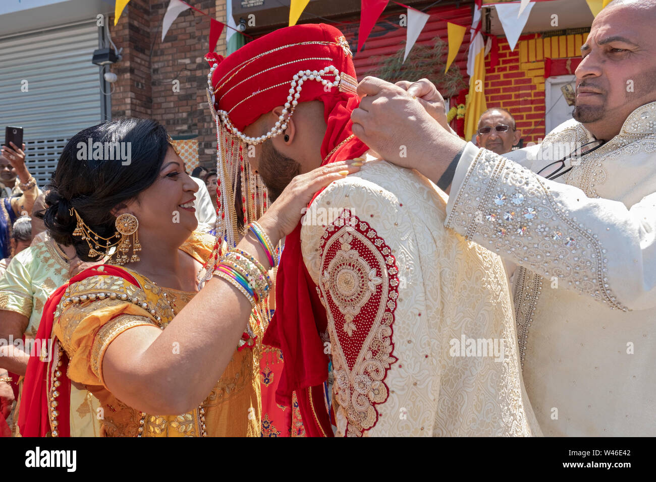 Lors d'une cérémonie de mariage traditionnelle hindoue le marié est accueilli par la mère de la mariée & oncle avant d'entrer dans le temple. En Ozone Park, Queens, NY Banque D'Images