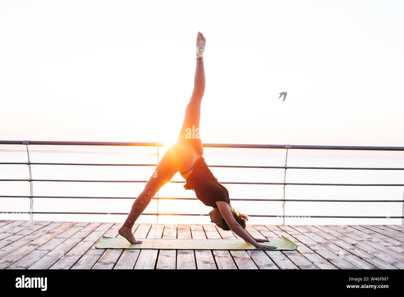 Les jeunes adultes de sexe féminin faisant du yoga en face de mer Banque D'Images