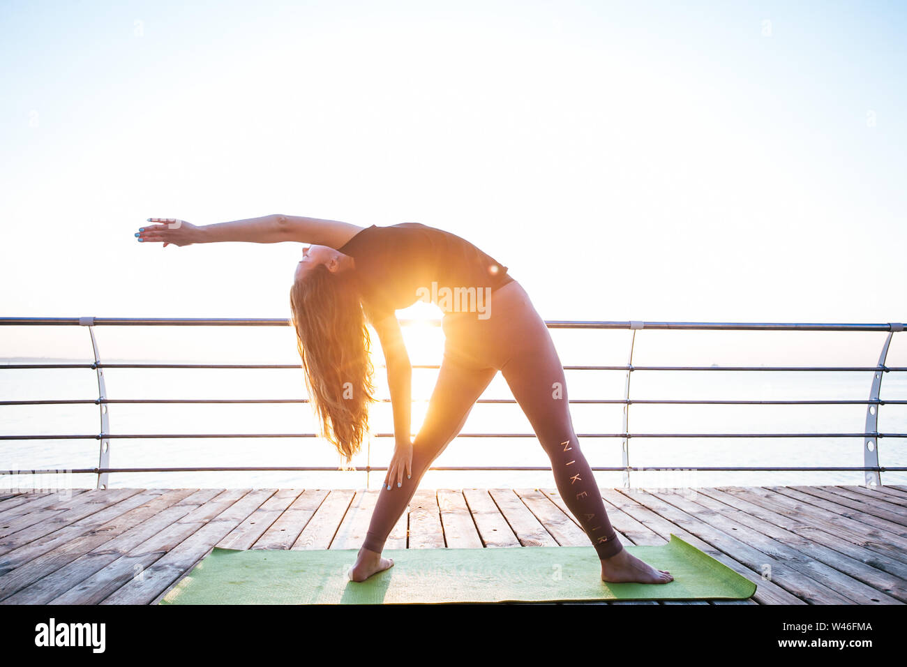 Les jeunes adultes de sexe féminin faisant du yoga en face de mer Banque D'Images