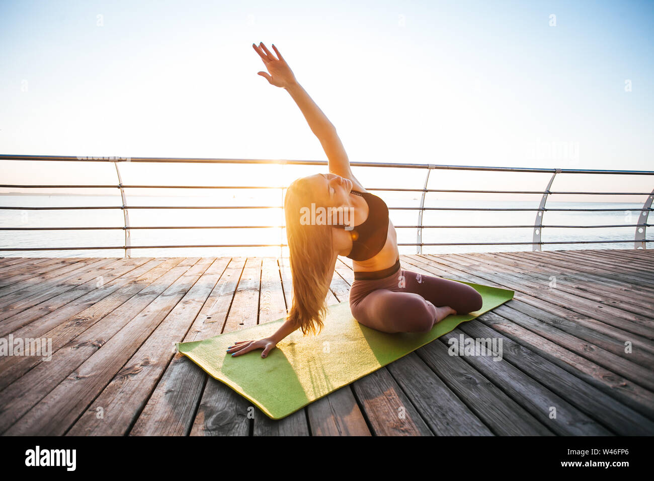 Les jeunes adultes de sexe féminin faisant du yoga en face de mer Banque D'Images