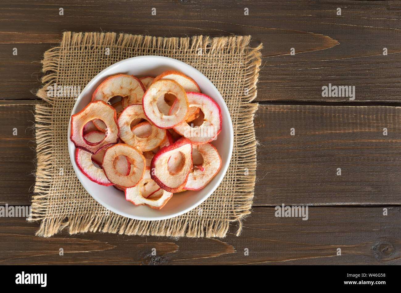 L'alimentation végétarienne. Anneaux de pommes séchées dans un bol blanc, vue du dessus Banque D'Images