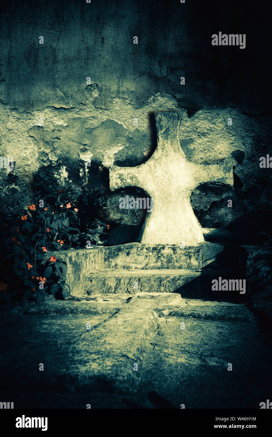 Abandonné tombe du spooky sombre nuit sur un ancien cimetière. Pierre tombale croix à côté de l'église en ruines du mur. Le mal et la mort concept Banque D'Images