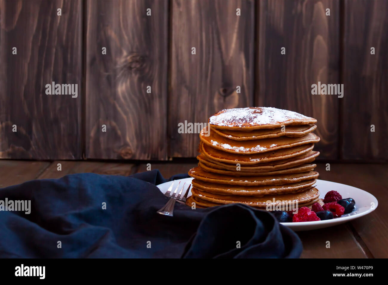 Crêpes aux fruits rouges savoureux golden saupoudré de sucre sur fond de bois. Banque D'Images